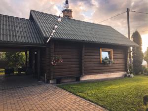 a log cabin with a window and a roof at Viesu nams SAKNĪTES in Dzērbene