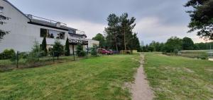 a dirt road in front of a building at NASZE BIAŁE pokój 2 osobowy in Okuninka