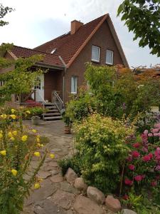 a house with a garden of flowers in front of it at Ostseenähe Homestay in Gadebusch
