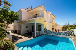 a villa with a swimming pool in front of a house at Albuera Villa in Albufeira