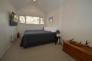 a bedroom with a bed and two windows at Wintergreen 10 in Thredbo