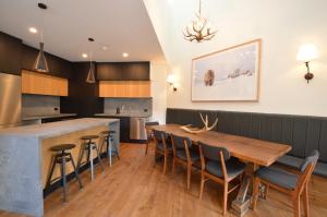 a kitchen and dining room with a wooden table and chairs at Wintergreen 10 in Thredbo