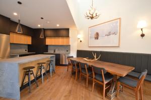 Una cocina y un comedor con mesa y sillas de madera. en Wintergreen 10, en Thredbo