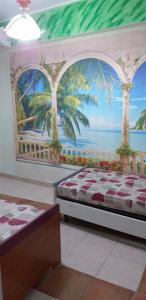 a bedroom with a mural of palm trees on the wall at appartamento Claudia in Roccalumera