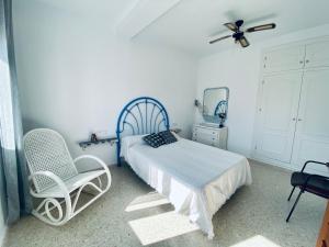 um quarto com uma cama e 2 cadeiras e uma ventoinha de tecto em Ramón y Cajal 6 em Chipiona