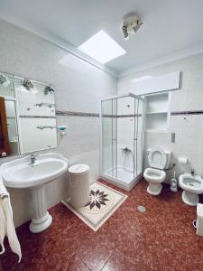 uma casa de banho com um lavatório, um chuveiro e um WC. em Ramón y Cajal 6 em Chipiona
