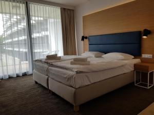 sypialnia z dużym łóżkiem i dużym oknem w obiekcie Seaside Park Resort w Kołobrzegu