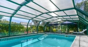 an indoor swimming pool with a retractable roof at Domaine l'instant du Colibri in Le Mesnil-Théribus