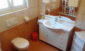 une salle de bain avec un lavabo blanc et des toilettes dans l'établissement MERI, à Rab 20 autres photos