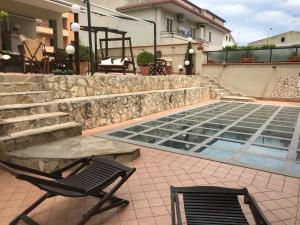 a patio with two chairs and a table and a pool at Dino's B&B in Casapulla