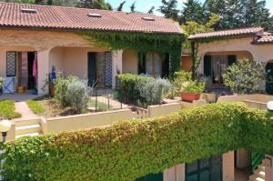 an ivy covered fence in front of a house at ELBA Casa Mare Natura in Magazzini