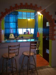 una cocina con 2 taburetes de barra en Departamento confortable, en Ciudad de México