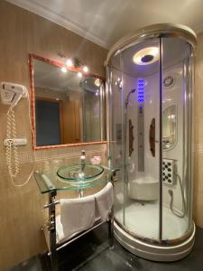 y baño con ducha de cristal y lavamanos de cristal. en Hotel Pedramar, en A Lanzada
