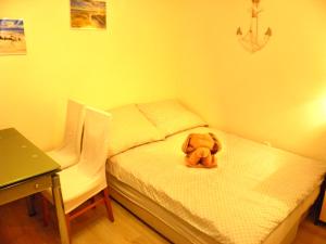 a teddy bear sitting on a bed in a room at APARTAMENT BERMUDY in Świnoujście