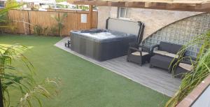 a patio with a hot tub and chairs on a lawn at Avshalom Holiday Apartments in Eilat