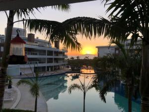 a view of a pool with a building and a sunset at Marine Home Resort- piscina aquecida-hidromassagem in Florianópolis