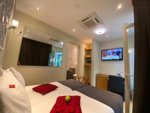 ein Schlafzimmer mit einem Bett mit zwei roten Kissen darauf in der Unterkunft Alp Hotel in Amsterdam