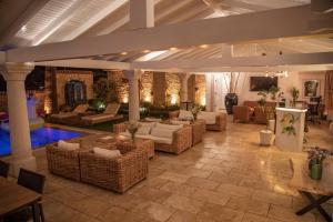 a large living room with wicker furniture and a pool at Alaçatı Limonaia Hotel in Alaçatı
