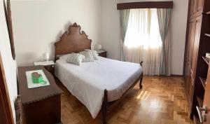 a bedroom with a large bed and a window at Casa Oliveira in Vila do Conde