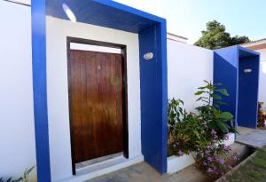 une maison bleue et blanche avec une porte en bois dans l'établissement Rafflesia Resort, à Lundu