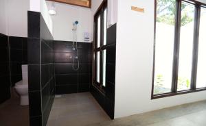 a bathroom with a shower and a toilet at Rafflesia Resort in Lundu
