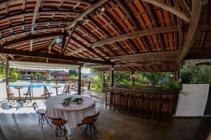 een patio met een tafel en stoelen en een zwembad bij Quinta dos Lemos in Araxá