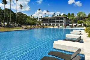 a large swimming pool with chairs and a building at Seda Lio El Nido Palawan in El Nido
