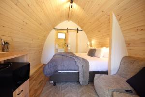 ウォンサッギにあるWonthaggi Park Lane Holiday Parkの木製の部屋にベッド1台が備わるベッドルーム1室があります。