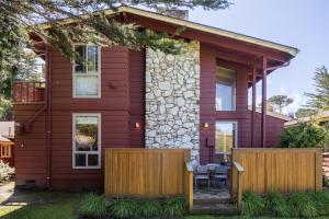 uma casa com uma cerca de madeira em frente em Andril Fireplace Cottages em Pacific Grove