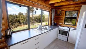 una cocina con fregadero y una ventana en una cabaña en Mt Lyford Holiday Homes, en Mt Lyford