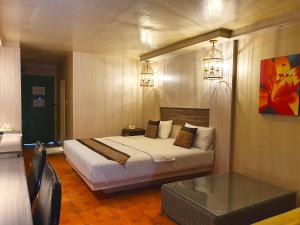 ein Schlafzimmer mit einem Bett und einem Tisch darin in der Unterkunft The Montana Lodge-Sathorn in Bangkok