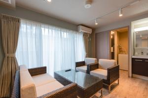 a living room with a couch and chairs and a table at VILLA KOSHIDO KOTONI annex in Sapporo