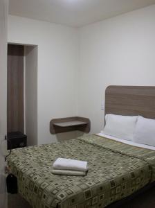 Una habitación de hotel con una cama con una toalla. en Hotel Winn Comfort en Tlaxcala de Xicohténcatl