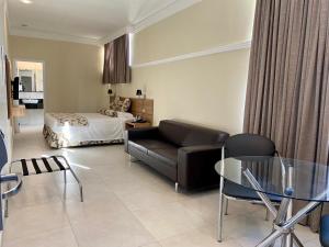 una sala de estar con un sofá y una cama en Wynn Batel, en Curitiba