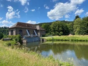 ein altes Gebäude neben einem Wasserkörper in der Unterkunft Ferienhaus "Am Stauwerk" in Engelskirchen