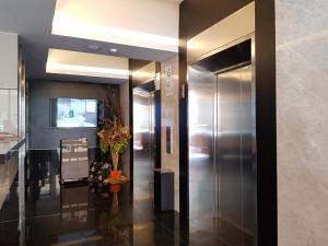 a elevator in a building with a hallway with flowers at Leo Palace Hotel in Kuala Lumpur