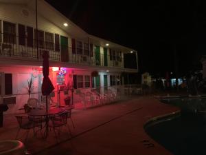 a building with a table and chairs next to a pool at night at Colonial motel in Wisconsin Dells