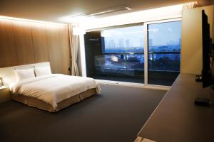 a bedroom with a bed and a large window at Incheon Stay Hotel in Incheon