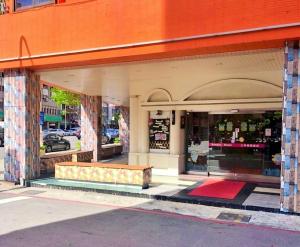 un front de magasin avec un banc devant lui dans l'établissement Sanduo Hotel, à Kaohsiung