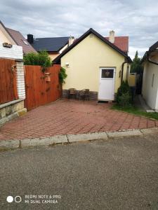 a patio with two chairs and a house at Apartmán 4you in Buchlovice