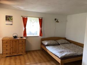 um quarto com uma cama, uma cómoda e uma janela em Chalupa U sjezdovky, Zadov 22 em Stachy