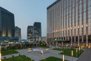 um grande edifício com uma fonte em frente em Holiday Inn Express Beijing Yizhuang, an IHG Hotel em Daxing