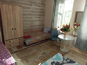 a bedroom with a bed and a table and a cabinet at Номер в Гостевом доме у моря in Odesa