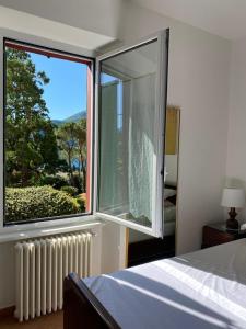 a bedroom with a bed and a large window at Quater Apartments - Tremezzina in Mezzegra