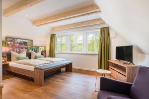 1 dormitorio con 1 cama, TV y sofá en Heidjers Hus Undeloh en Undeloh