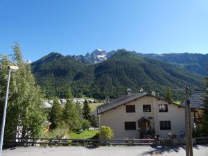 a house with mountains in the background at Chalet les Ombrettes in Ceillac