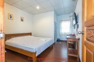 niewielka sypialnia z łóżkiem i oknem w obiekcie บ้านพักศรีสมบูรณ์ เชียงคาน w mieście Chiang Khan