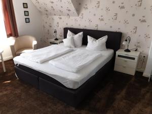 un letto con lenzuola e cuscini bianchi in una camera da letto di Villa zur schönen Aussicht a Bad Salzuflen