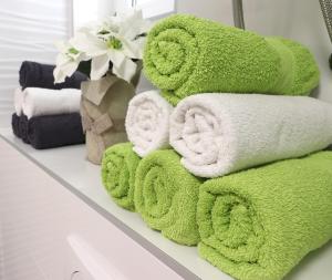 stos zielonych ręczników na półce w łazience w obiekcie Apartments Medulin - Orijeta w Medulinie