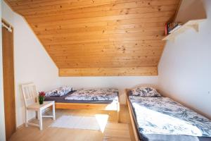 two beds in a room with a wooden ceiling at Alpine house Antonia in Trenta